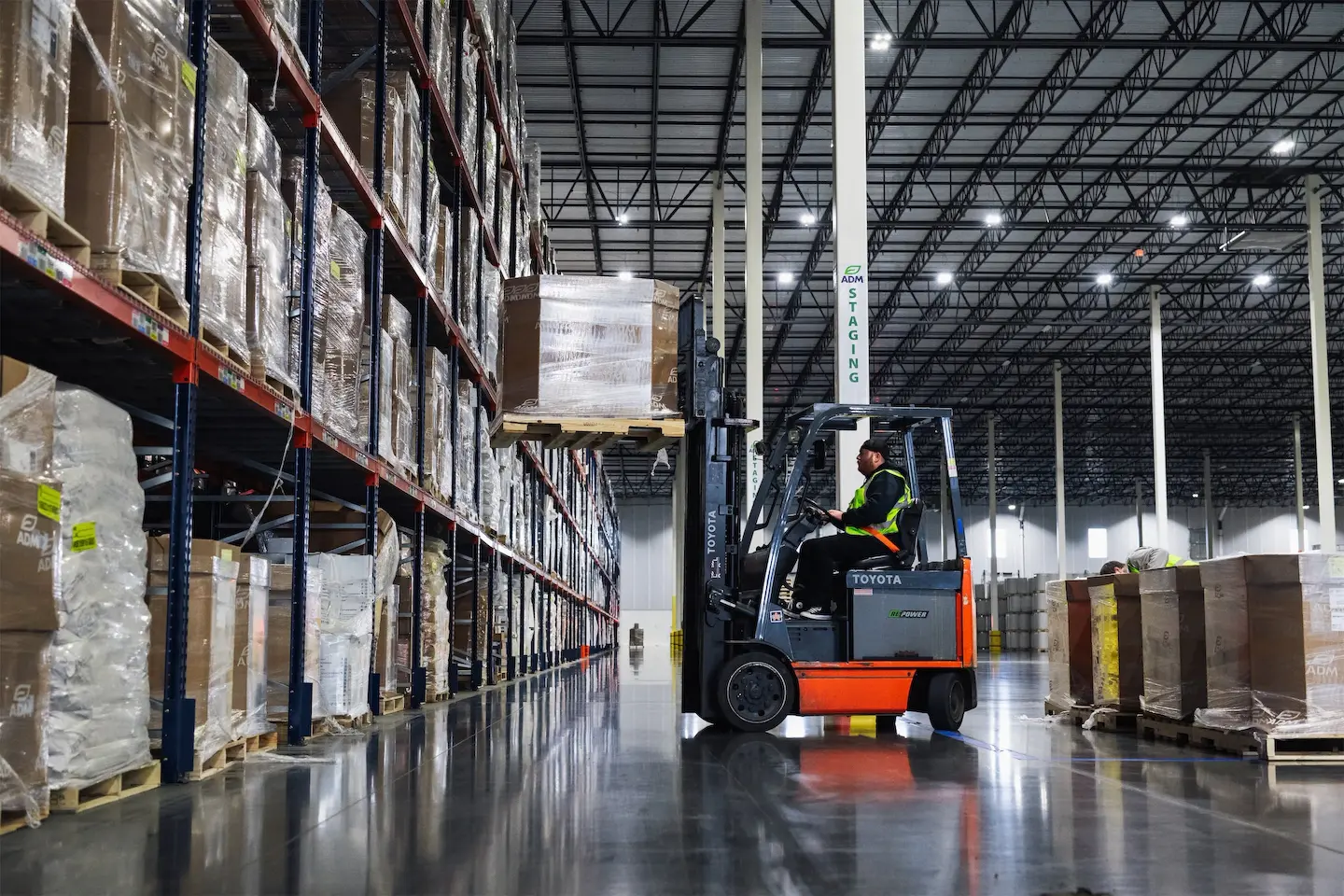 Forklift operator loading pallet onto rack