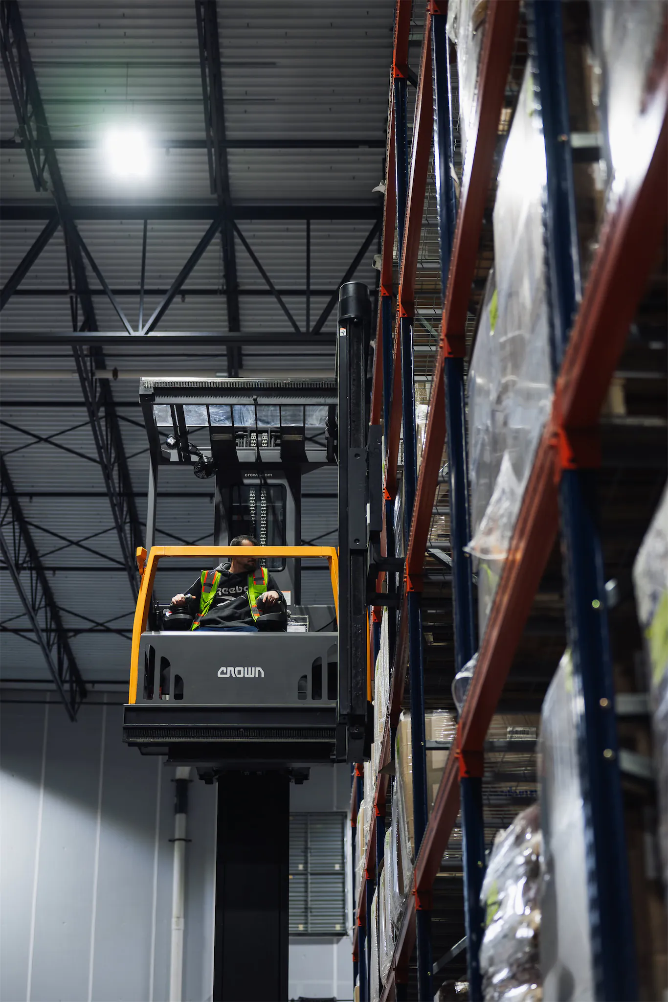 Extended warehousing lift picking an order from the top shelf